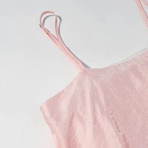 Détail du caraco en satin rose montrant les coutures de la bretelle et le tissu soyeux