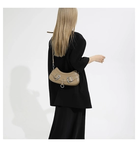 Detail of khaki crescent shoulder bag with silver buckles and ring on a model