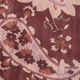 Detailed close-up of dark reddish-brown chiffon fabric with paisley and floral patterns