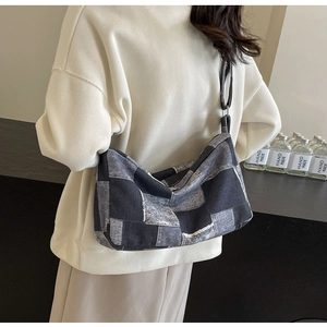 Détail du sac à bandoulière en denim bleu avec motif à carreaux sur tenue décontractée