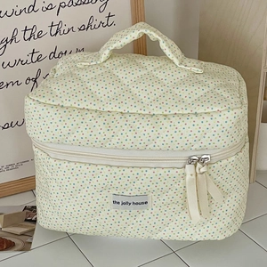 Close-up of the quilted cotton makeup bag with colorful polka dots and a sturdy handle