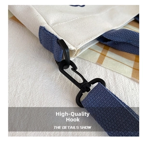 Detail shot of durable black plastic swivel hook and blue strap on canvas tote bag