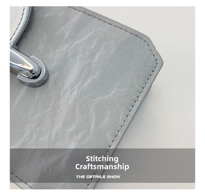 Macro shot of marble textured crossbody bag with silver lock and detailed stitching