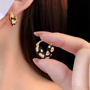 Detail eines vintage herzförmigen Ohrrings mit Leopardenmuster und Goldbeschichtung