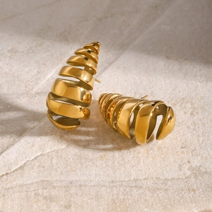 Macro shot of 18K gold plated stainless steel teardrop earrings on a stone background