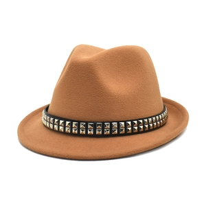 Dettaglio del cappello fedora caramello con fascia in pelle nera e borchie quadrate argento