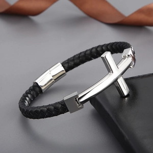 Detail of woven black leather bracelet with silver cross and magnetic clasp closure