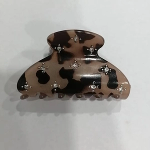 Detail view of tortoiseshell hair claw clip with star shaped rhinestone embellishments
