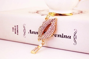Close-up of sparkling rhinestone red lips keychain with a mini lipstick pendant