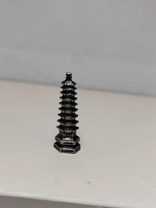Close-up of a miniature multi-tiered metal pagoda statue for micro landscape bonsai decor