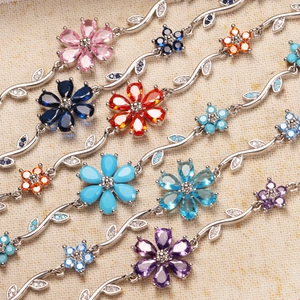 Macro detail of silver flower bracelets with colorful cubic zirconia and vine links