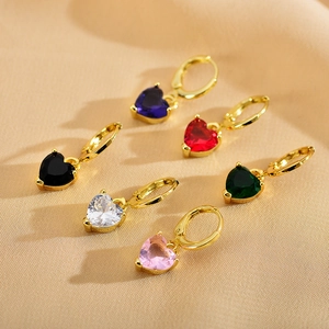 Detailed view of colorful heart-shaped crystal charms on golden huggie hoop earrings