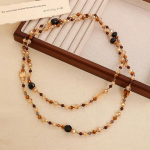 Detailed macro view of retro bohemian double-layered beaded necklace with amber faceted beads