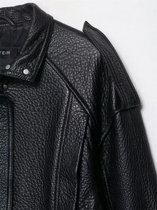 Detail der schwarzen PU-Lederjacke mit Reverskragen und silbernen Druckknöpfen