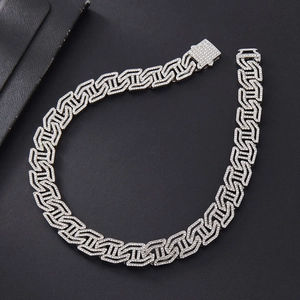 Detailed view of silver cuban link chain with sparkling diamonds on a black background