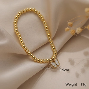 Detail of 11g gold bead bracelet featuring a 1.1cm white enamel butterfly pendant