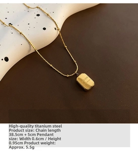 Close-up of gold square letter pendant with beaded chain on a designer background