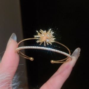 Detail of gold double-layered bangle with sparkling zircon firework starburst design