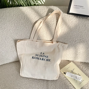 Macro detail of high-quality canvas fabric texture and blue typography on tote bag