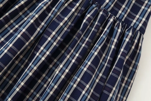 Makro-Detail des plissierten Karostoffs in Navy und Blau mit hochwertiger Textur