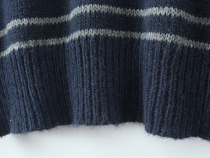 Close-up of the fuzzy knit texture and ribbed hem on this striped long sleeve polo shirt