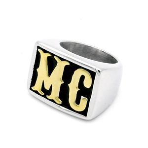 Detailed view of silver stainless steel ring featuring gold MC letters on black background