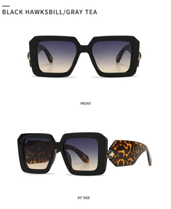 Detail of baroque sunglasses featuring a gold snake head on tortoiseshell temples