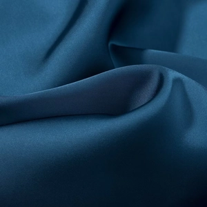 Navy blue satin dress fabric featuring elegant glossy texture and smooth draped folds