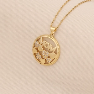 Macro shot of gold MOM heart pendant necklace with shimmering zircon crystal inlay details