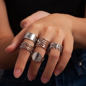 Detail showing five-piece vintage silver rings with coin relief and multi-layered bands