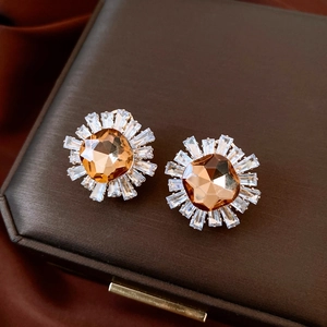 Macro shot of 18k gold plated sunflower stud with amber stone and zircon crystals