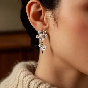 Elegant zircon hollow flower dangle earrings with silver needle shown on model