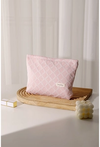 Dettaglio della borsa da trucco rosa a scacchi in tela su vassoio di legno con decorazioni