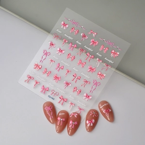 Pink bow nail art stickers with crystal rhinestones and pearls on a transparent sheet