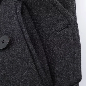 Close-up of charcoal grey wool blend fabric and round black buttons on long coat