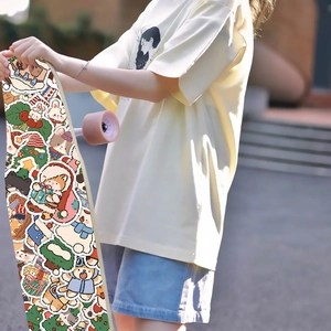 Skateboard deck covered in festive Christmas stickers featuring cats and bears