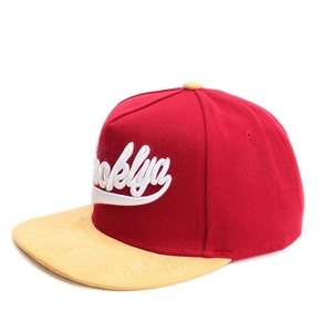 Détail de la casquette snapback rouge avec broderie Brooklyn et visière en daim jaune