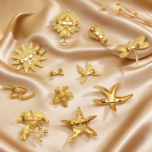 Golden sun butterfly heart brooches set displayed on luxury champagne silk fabric background