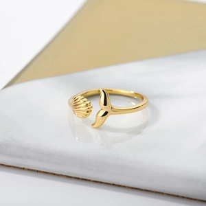 Close-up of 18k gold-plated open ring featuring detailed whale tail and seashell motifs