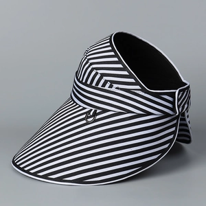 Détail de la visière rayée noir et blanc avec large bord et boucle décorative en anneau métal