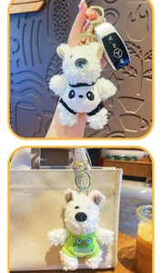 Cute plush puppy keychain in panda and green frog outfits used as a bag charm