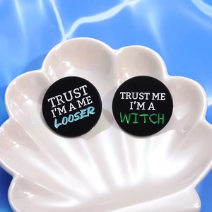 Minimalist black round metal badges with colorful 'TRUST ME' slogans on shell tray