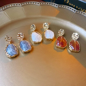 Vue détaillée de boucles d'oreilles rétro en résine bleue, blanche et ambrée