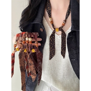 Ethnic style chiffon scarf necklace with wooden beads and vintage patterns on a neck model