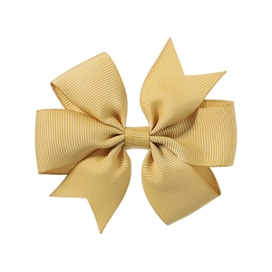 Detailed close-up of golden yellow grosgrain ribbon bow with elegant ribbed texture for hair clips