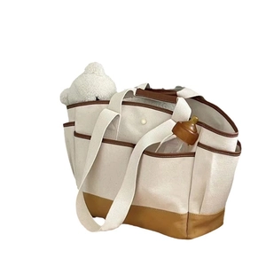 Large capacity canvas diaper bag with leather trim and wide shoulder strap in cream white