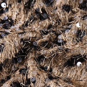 Macro detail of black and gold leopard print sequin fabric with fringe texture