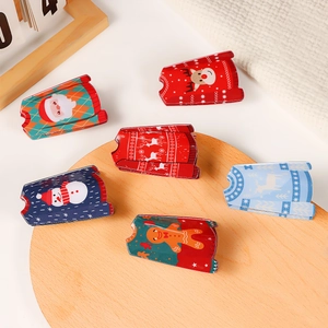 Christmas themed ugly sweater shaped metal hair claws with festive reindeer and santa patterns