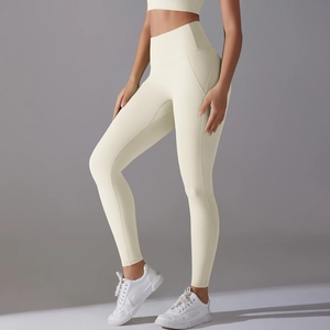Macro detail of high-waist seamless cream yoga pants with ergonomic stitching and soft fabric