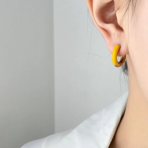 Macro detail of geometric enamel earring with half yellow oil and half gold finish